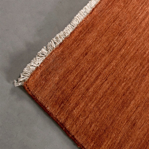 Rustfarvet Skagen-tæppe fra HC Interior Rugs i håndvævet uld, 80 x 150 cm, med frynser