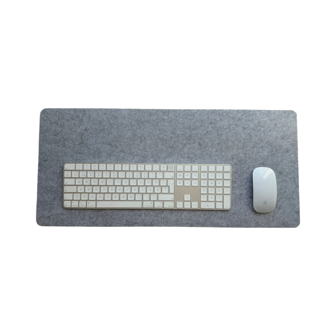 Gråt skrivebordsunderlag fra Deskneat med mus og tastatur ovenpå