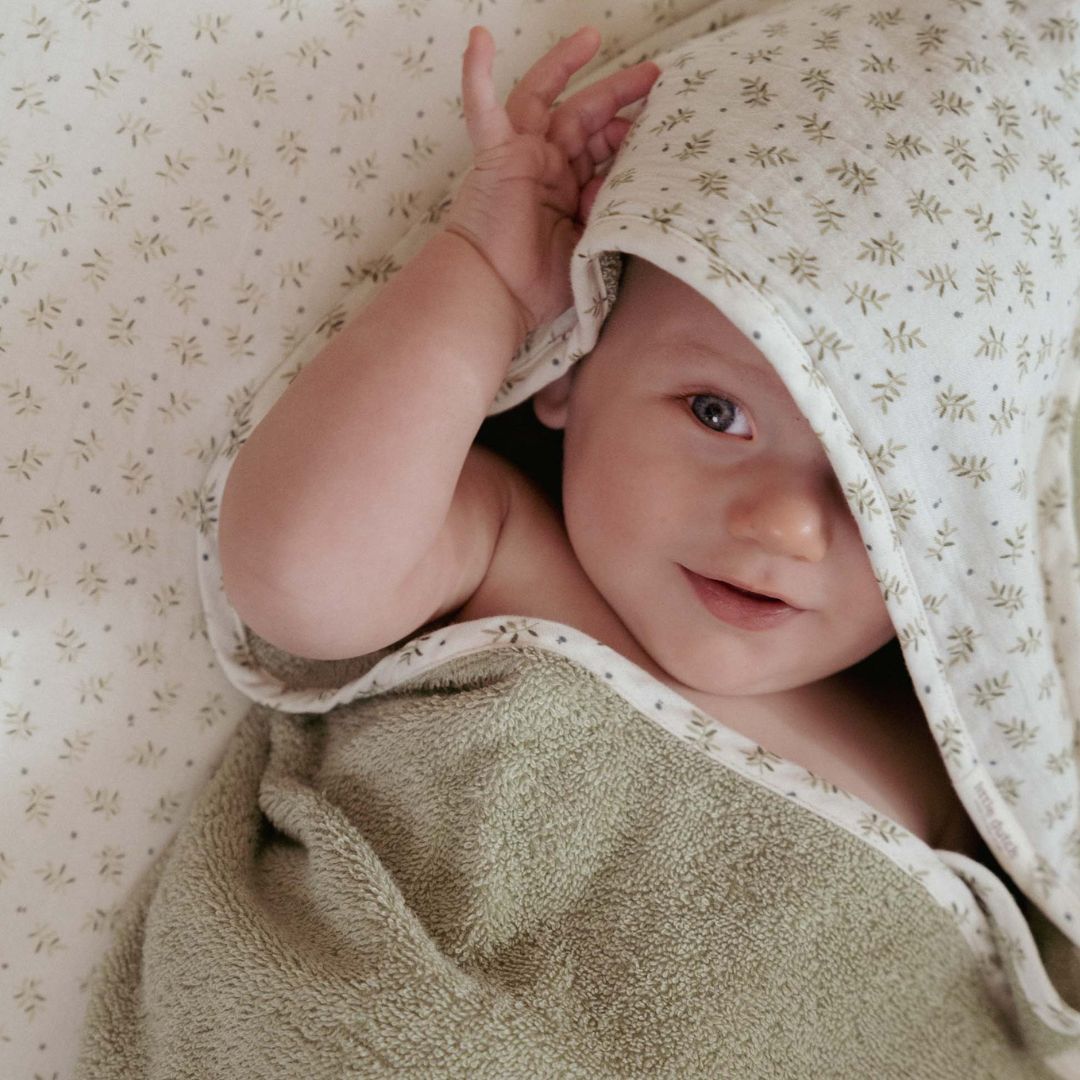 Støvet grønt babyhåndklæde i frotté med lys hætte og blåbærblade fra Little Dutch
