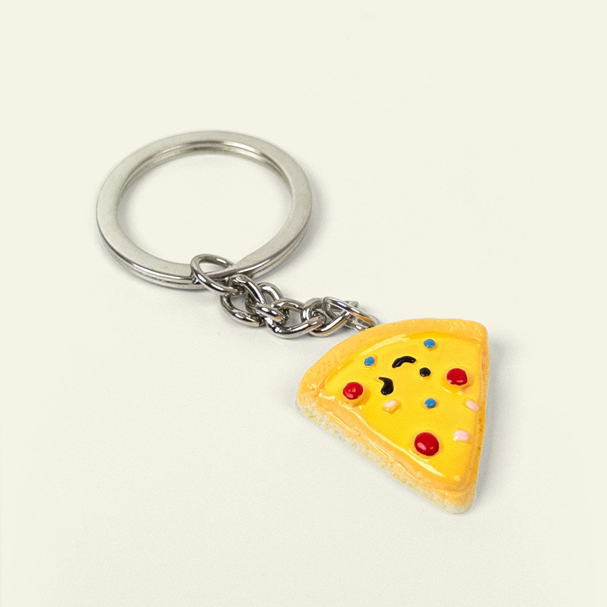 Nøglering formet som et stykke pizza med ost og toppings